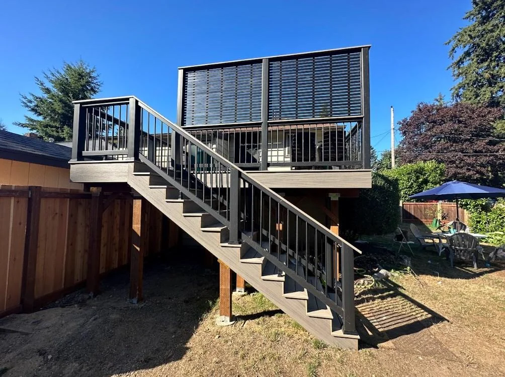 Olympic Decks View From Below Of An Elevated Azek Vintage Deck Replacement In Bellevue, Featuring Black Railings And A Privacy Screen.